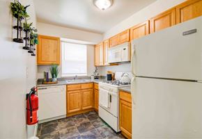 Marlton apartment for rent - a kitchen with white appliances and wooden cabinets
