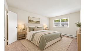 Marlton apartment for rent - A bedroom with a bed, nightstand, and a painting on the wall.