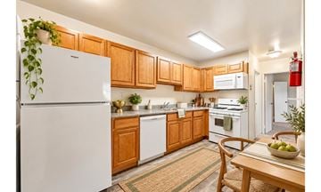 Marlton apartment for rent - A kitchen with wooden cabinets and a white fridge.