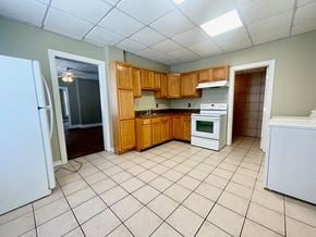 Louisville house for rent - an empty kitchen with wooden cabinets and white appliances