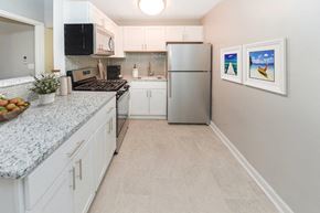 Long Branch apartment for rent - a kitchen with white cabinets and a stainless steel refrigerator