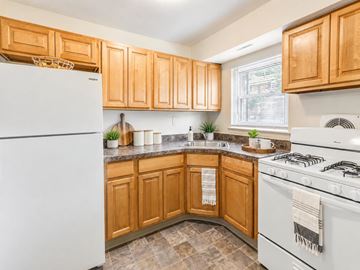 Freehold apartment for rent - A kitchen with wooden cabinets and a white refrigerator.