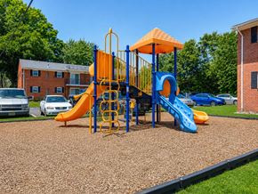 Freehold apartment for rent - A playground with a yellow and blue slide and a yellow and blue structure.