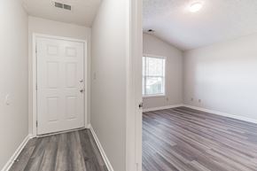 Louisville house for rent - an empty bedroom with a white door and wood flooring
