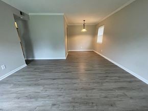 Louisville house for rent - a empty living room with a wood floor and a ceiling light