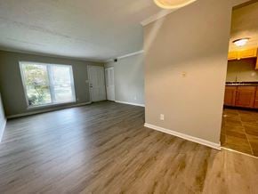 Louisville house for rent - an empty living room with wood floors and a window