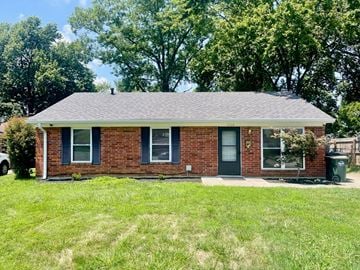 Louisville house for rent - a small brick house with a yard and trees
