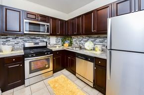 New Brunswick apartment for rent - a kitchen with stainless steel appliances and brown cabinets