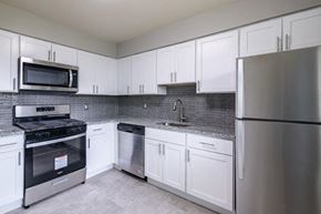 Piscataway apartment for rent - a kitchen with white cabinets and stainless steel appliances