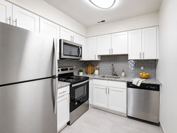 Clementon apartment for rent - A modern kitchen with a refrigerator, microwave, oven, and dishwasher.