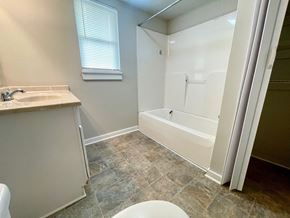 New Albany house for rent - A white bathroom with a sink, toilet, and bathtub.