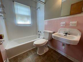 New Albany apartment for rent - A white toilet sits next to a white sink in a bathroom.