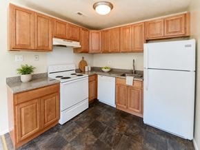 West Deptford apartment for rent - A kitchen with wooden cabinets and a white refrigerator.