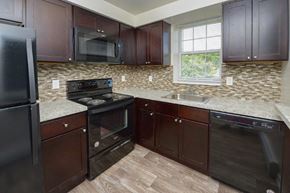 Claymont apartment for rent - a kitchen with a stove and a sink and a microwave