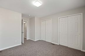 New Albany apartment for rent - an empty bedroom with white doors and carpeted flooring