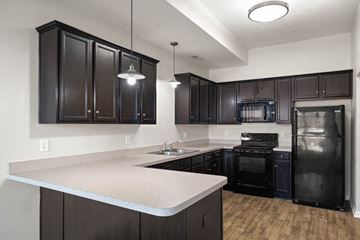 New Albany apartment for rent - a kitchen with black appliances and white counter tops
