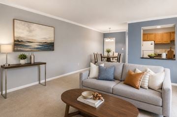 Randallstown apartment for rent - A living room with a grey couch, a wooden table, and a painting on the wall.