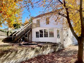 Louisville apartment for rent - A house with a white exterior and a stone wall in front.