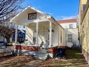 Louisville apartment for rent - A small white house with a porch and a blue house in the background.