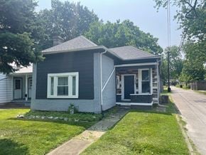 Jeffersonville house for rent - A small house with a grey roof and white trim is surrounded by a grassy lawn.