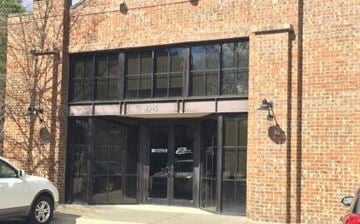 Birmingham apartment for rent - A white car is parked in front of a brick building with a black awning.