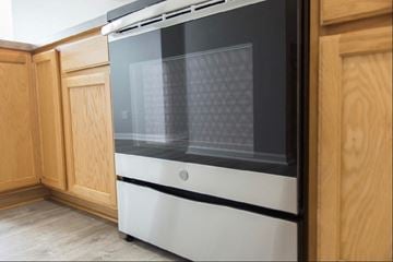 New Albany apartment for rent - a white oven in a kitchen with wooden cabinets