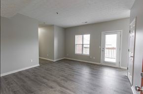 New Albany apartment for rent - an empty living room with wood floors and a door to a balcony