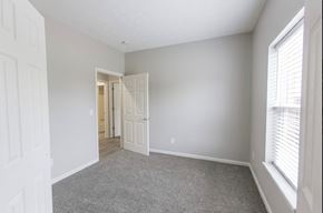 New Albany apartment for rent - a bedroom with a door to a hallway and a carpeted floor