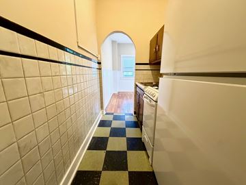 Louisville apartment for rent - A hallway with a checkered floor leads to a kitchen.