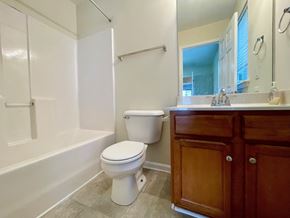 Louisville house for rent - A white toilet sits next to a bathtub in a bathroom.