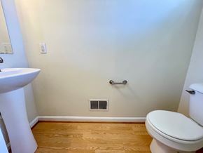 Louisville house for rent - A white toilet in a bathroom with a wooden floor.