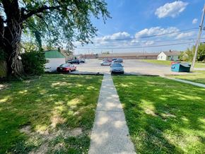 New Albany apartment for rent - A tree-lined sidewalk with cars parked in the background.