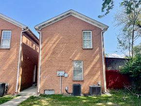 New Albany apartment for rent - A red brick house with a white window and a door.
