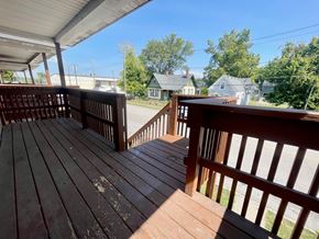 New Albany apartment for rent - A wooden deck with a railing and a view of a street and houses.