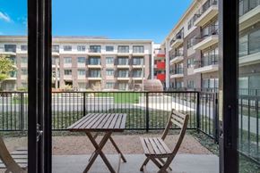 Plano house for rent - a balcony with a table and chairs in front of an apartment building