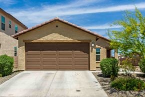 Tucson house for rent - a garage door in front of a house with a driveway