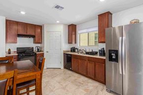 Tucson house for rent - a kitchen with stainless steel appliances and a wooden table