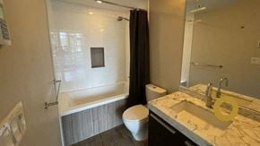 Vancouver house for rent - A bathroom with a toilet, sink, and bathtub.