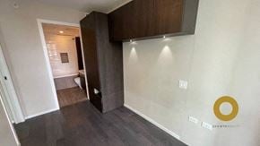 Vancouver house for rent - A room with a dark wood floor and a white wall with a gold logo on it.