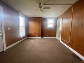 New Albany apartment for rent - an empty living room with a ceiling fan and wood paneling