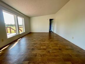 Charlestown house for rent - A room with a wooden floor and a door on the right side.