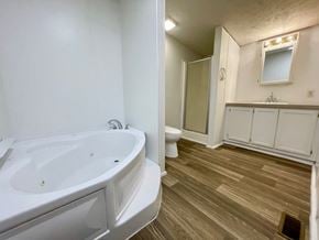 Charlestown house for rent - A white bathroom with a wooden floor and a white bathtub.