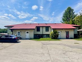 New Albany apartment for rent - A car is parked in front of a building with a red roof.