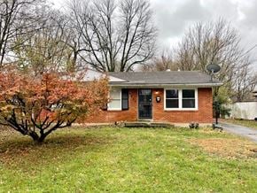 Louisville house for rent - a small brick house with a yard and a tree