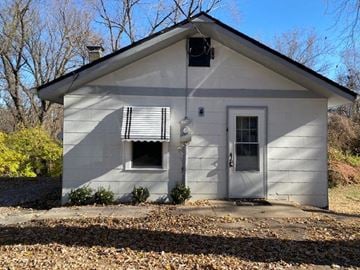Chesterfield house for rent - A small white house with a broken window and a door.