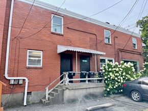 Louisville apartment for rent - A red brick house with a car parked in front.