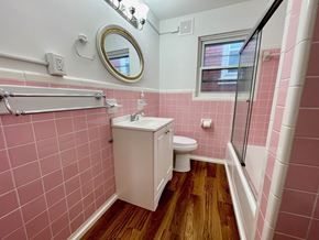 Louisville apartment for rent - A bathroom with pink tiles and a white toilet.