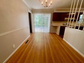 Louisville house for rent - A room with wooden floors and a chandelier.