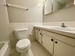 Louisville house for rent - A white toilet with a white sink and a white bathtub in a bathroom.