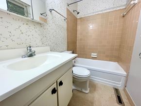 Louisville house for rent - A bathroom with a sink, toilet, and bathtub.